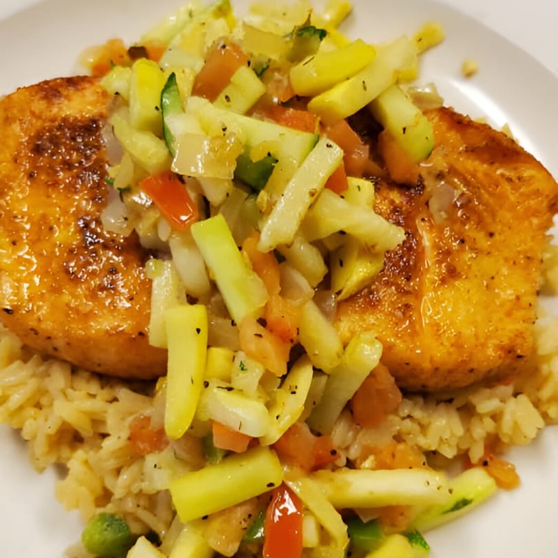 Compadres' grilled salmon with diced zucchini, tomatoes, and onions, served over rice.